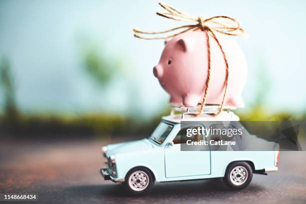 little pink piggy bank tied to the top of an old car - fundos investimento imagens e fotografias de stock