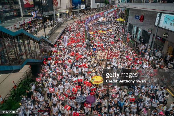 Protesters march on a street during a rally against the extradition law proposal on June 9, 2019 in Hong Kong China. Hundreds of thousands of...