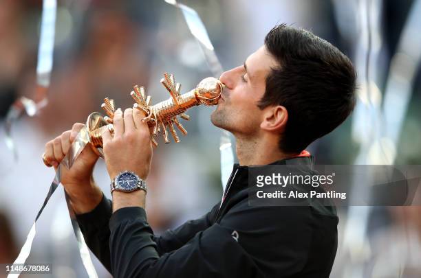 Novak Djokovic of Serbia celebrates victory as he kisses the winners trophy following the men's singles final against Stefano Tsitsipas of Greece...