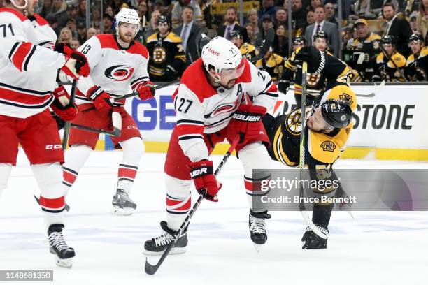 Justin Faulk of the Carolina Hurricanes checks Sean Kuraly of the Boston Bruins during the first period in Game Two of the Eastern Conference Final...