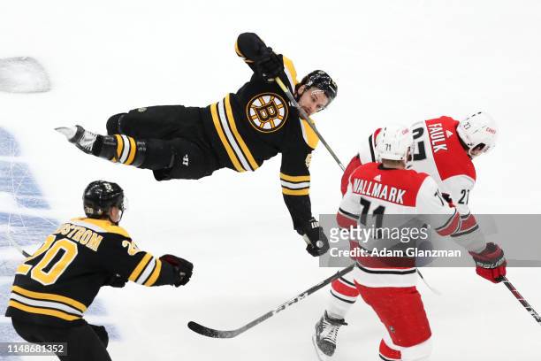 Justin Faulk of the Carolina Hurricanes checks Sean Kuraly of the Boston Bruins during the first period in Game Two of the Eastern Conference Final...