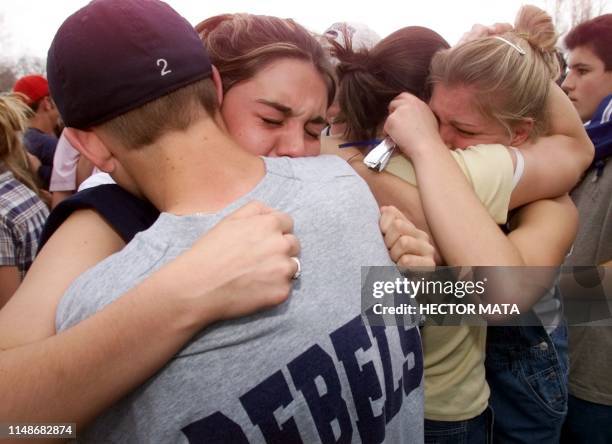 In this file photo school children hug each other in the parking lot 21 April 1999 outside Columbine High School in Littleton, CO, the site of a...