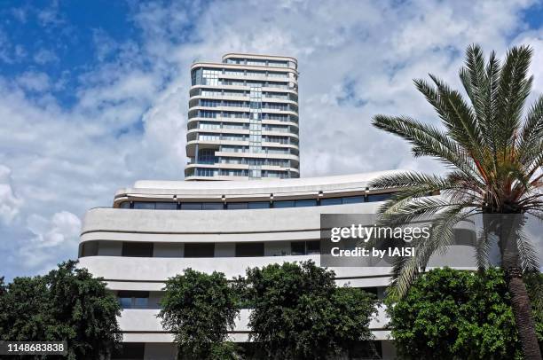 tel aviv, bauhaus building and palm tree, in the background, a more modern skyscraper - bauhaus art movement stock-fotos und bilder