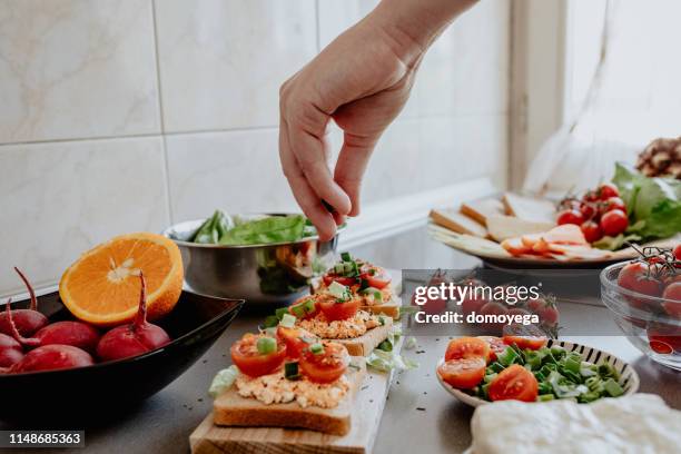 sazonar sabroso bruscheta en la cocina - bruschetta fotografías e imágenes de stock