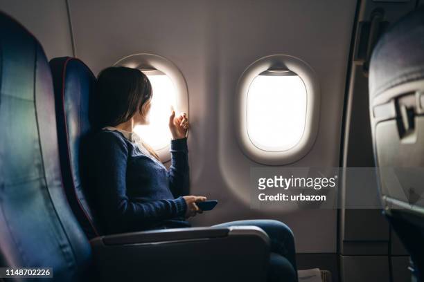mirando a través de la ventana del avión - window seat fotografías e imágenes de stock