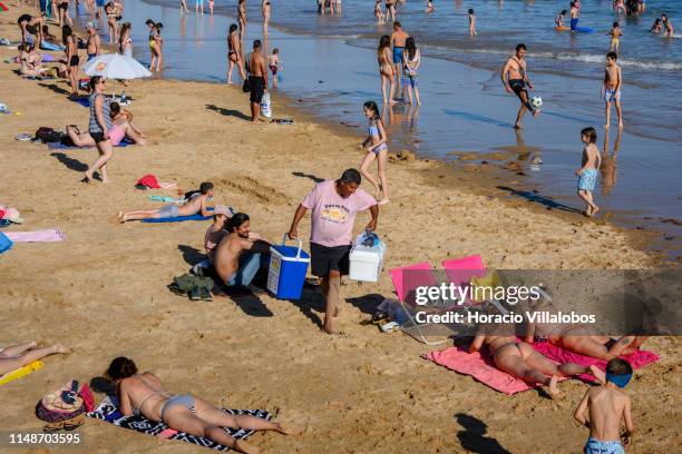 Vendor offers Bolas de Berlim to beachgoers crowding Praia do Carcavelos, the largest beach of the Lisbon-Estoril-Cascais coastline, during a hot...