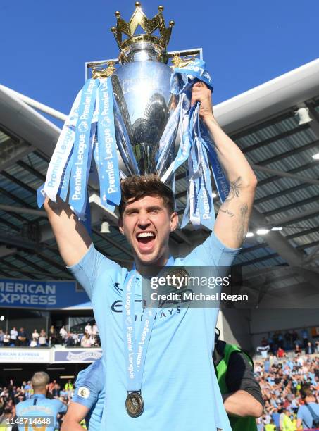 John Stones of Manchester City poses with the Premier League trophy during the Premier League match between Brighton & Hove Albion and Manchester...