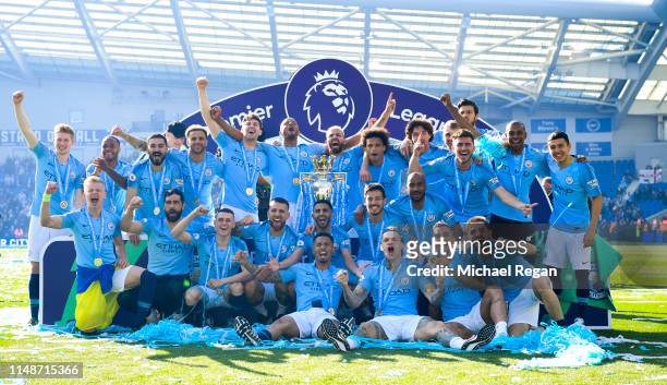 Manchester City pose with the Premier League trophy after the Premier League match between Brighton & Hove Albion and Manchester City at American...