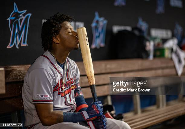 Ronald Acuña Jr. #13 of the Atlanta Braves kisses his bat in the dugout during the second inning against the Miami Marlins at Marlins Park on June 9,...