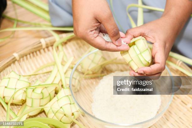 ketupat weaving for hari raya aidilfitri / eid-ul-fitr - ketupat stock pictures, royalty-free photos & images