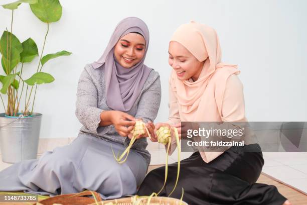 zwei malaiische muslimische frau wetdert ketupat für eid/eid-ul-fitr - malay culture stock-fotos und bilder