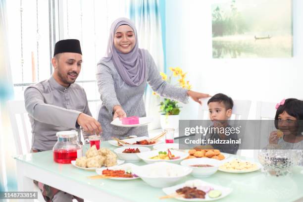 eine malaysische muslimische familie mit hari raya aidlfitri/eid-ul-fitr mahlzeiten - hari raya celebration stock-fotos und bilder