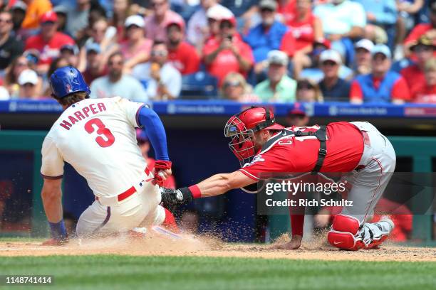 Bryce Harper of the Philadelphia Phillies is tagged out by catcher Curt Casali of the Cincinnati Reds on an attempted steal of home plate during the...