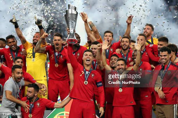 Portugal's forward Cristiano Ronaldo raises the trophy and celebrates with teammates after winning the UEFA Nations League Final football match...