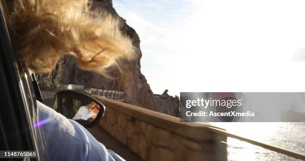 woman enjoys view and fresh air from passenger seat - car rear view mirror stock pictures, royalty-free photos & images