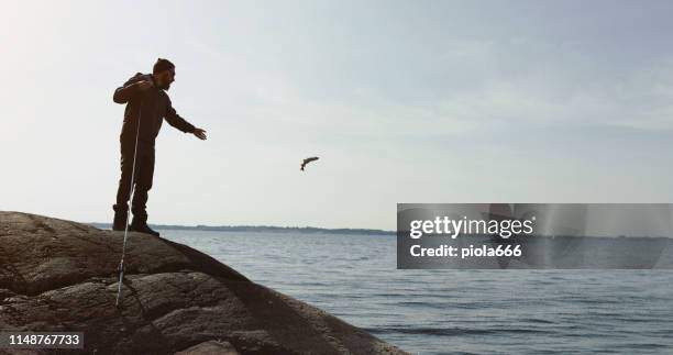 man fishing with a rod: releasing a fish - releasing fish stock pictures, royalty-free photos & images