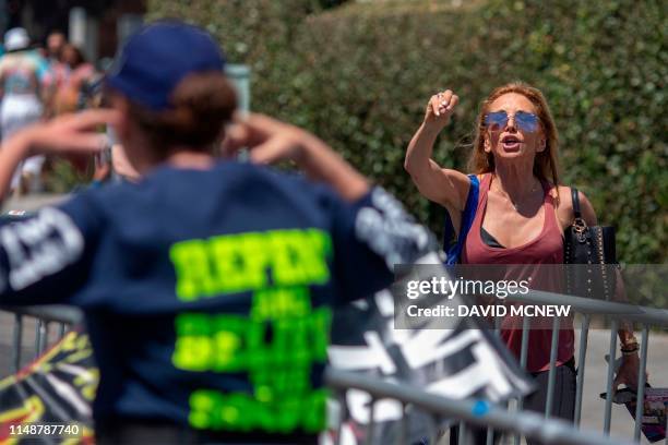 Woman with an anti-LGBTQ evangelical Christian group puts her fingers in her ears as a woman argues at her during the annual LA Pride Parade in West...
