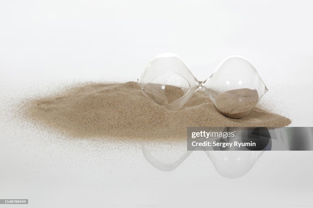 Broken hourglass in the sand