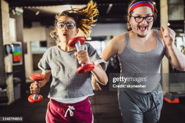 lustiges leichtathletik-ehepaar joggt beim sporttraining in einem fitnessstudio. - gym images stock-fotos und bilder