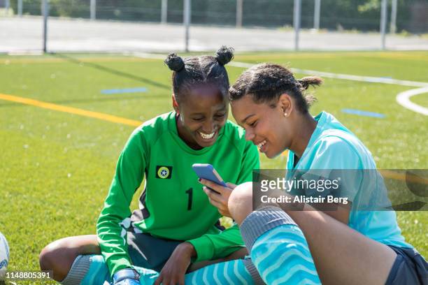 Teenage female soccer players looking at phone