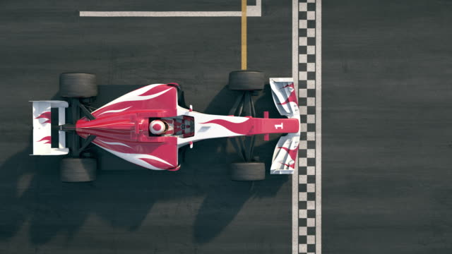 Top view of a formula one race car driving over finish line in slow motion