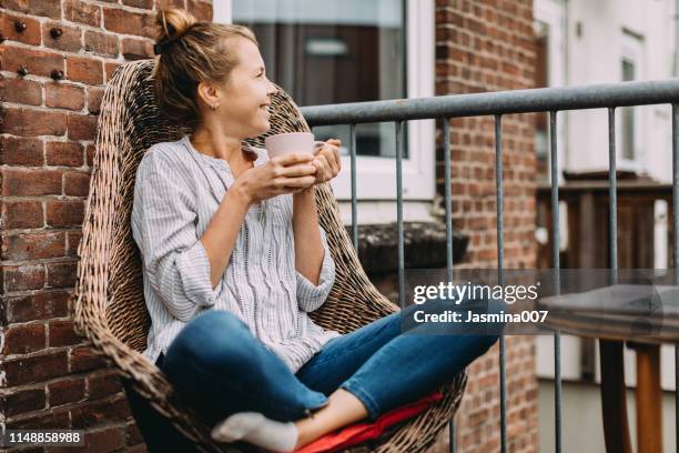jovencita bebiendo café en casa - té terraza fotografías e imágenes de stock