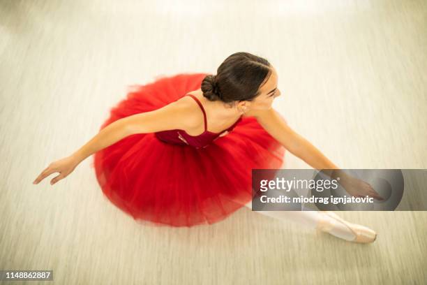 directly above teenage ballet dancer sitting on floor - red dress child stock pictures, royalty-free photos & images