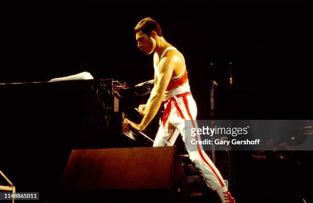 English Rock vocalist Freddie Mercury , of the group Queen, plays piano as he performs onstage at Byrne Arena, East Rutherford, New Jersey, August 9,...