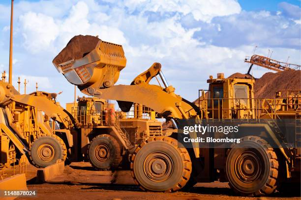 Excavators move iron ore at the port in Port Hedland, Australia, on Monday, March 18, 2019. Port Hedland is the nexus of Australias iron-ore...