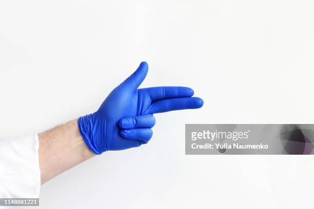 doctor's hand in blue medical glove being ready for consult - surgical glove stock pictures, royalty-free photos & images