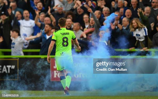 Dayle Grubb of Forest Green Rovers throws a flare off the pitch as Tranmere Rovers fans celebrate their first goal during the Sky Bet League Two...