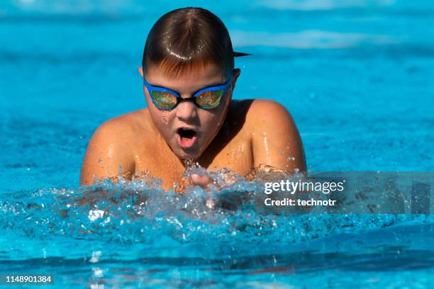スイミングプールでのティーンエイジャーの水泳平泳ぎ - ブレスト ストックフォトと画像