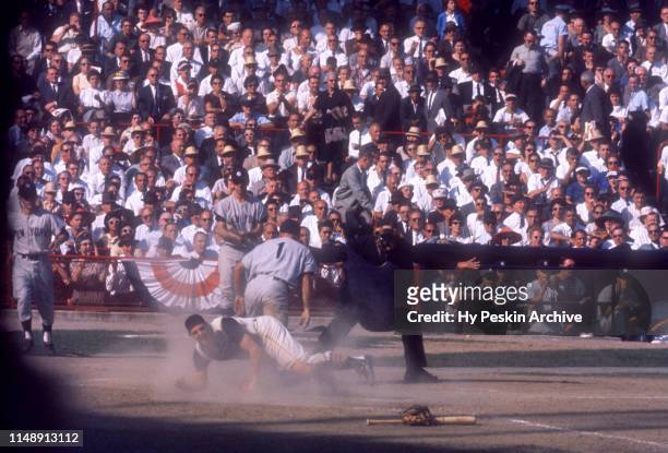 Bobby Richardson of the New York Yankees scores as catcher Hal Smith of the Pittsburgh Pirates is late with the tag during Game 6 of the 1960 World...