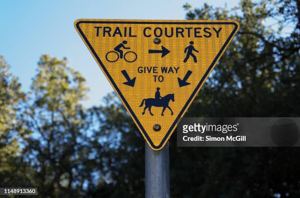 sign indicating cyclists should yield to hikers, and both cyclists and hikers should yield to horseriders on a shared trail in canberra, australia - give way 個照片及圖片檔