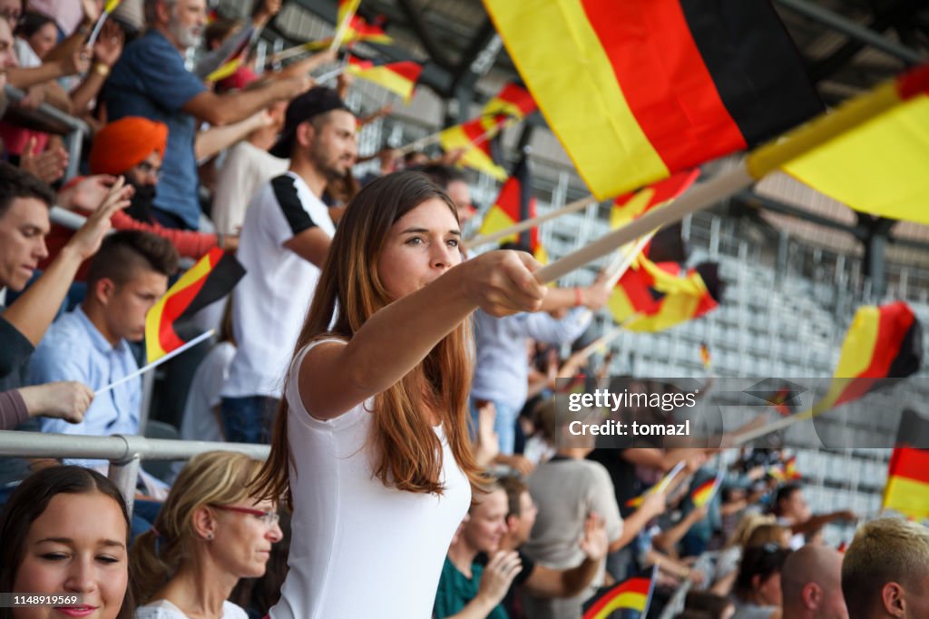 Young woman as spectator on a stadium with german flags