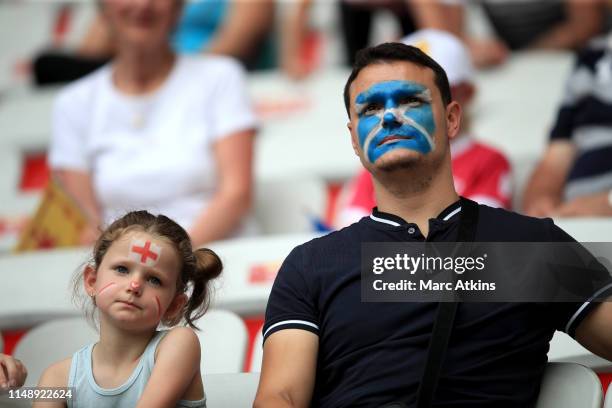 An young England fan looks on alongside an adult with their face painted in the colours of the Scottish saltire during the 2019 FIFA Women's World...