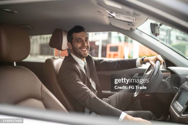 portrait of a happy driver looking out of car window - chauffeurs stock pictures, royalty-free photos & images