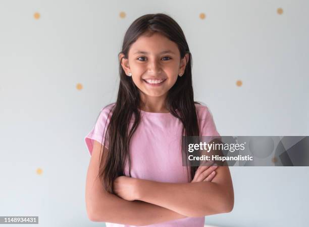 retrato de la hermosa niña latinoamericana frente a la cámara sonriendo con los brazos cruzados - 11 fotografías e imágenes de stock