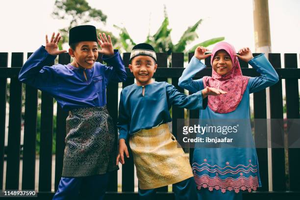 drie broers en zussen spelen voor het huis - eid al fitr celebration to mark the end of ramadan stockfoto's en -beelden