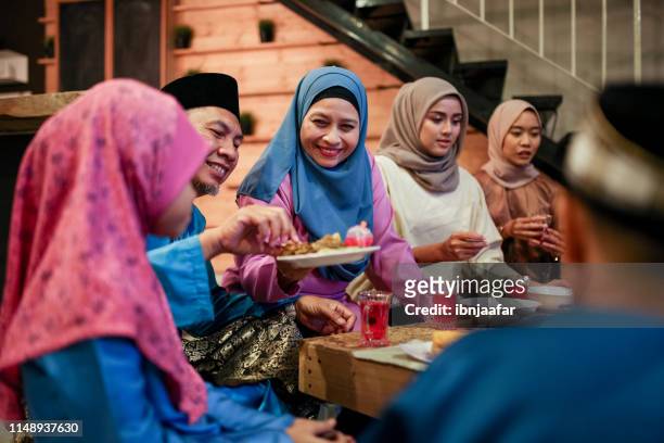 familiebijeenkomst en eten samen - eid al fitr celebration to mark the end of ramadan stockfoto's en -beelden