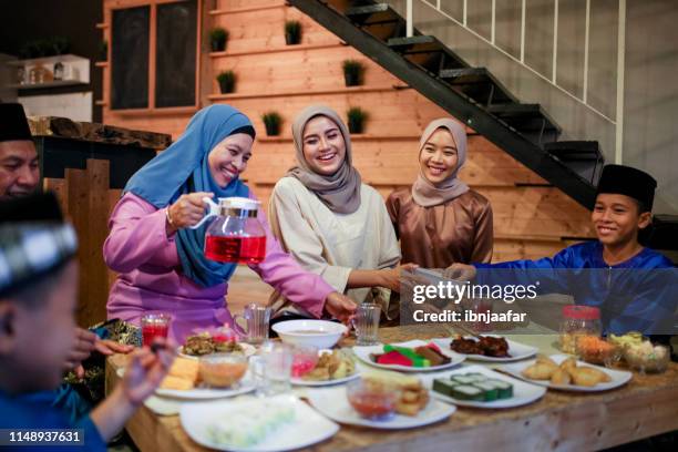 riunione di famiglia e mangiare insieme - muslim family foto e immagini stock