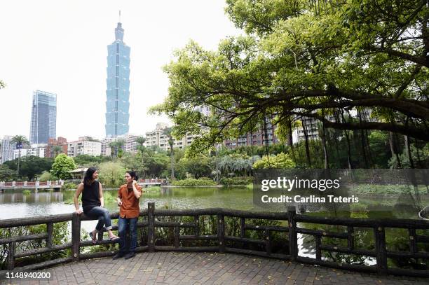 chinese man and woman talking in a park - chinesischer garten im klassischen stil stock-fotos und bilder