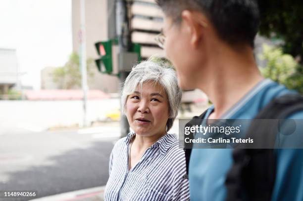 man and his senior mother on the street - taiwan family stock pictures, royalty-free photos & images