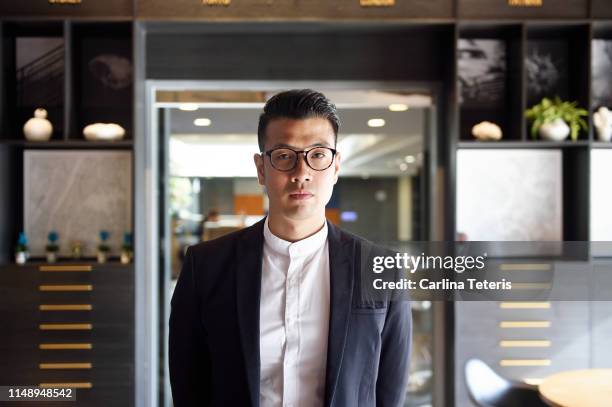 portrait of a well dressed man in an office - chinese male confident stock pictures, royalty-free photos & images