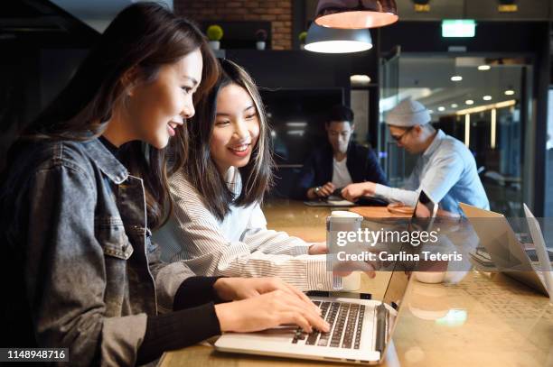 young women working together in a co-working space - taiwan culture stock pictures, royalty-free photos & images