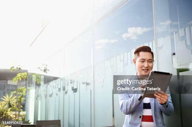 indonesian business man outdoors with a digital tablet - digitale transformation stock-fotos und bilder