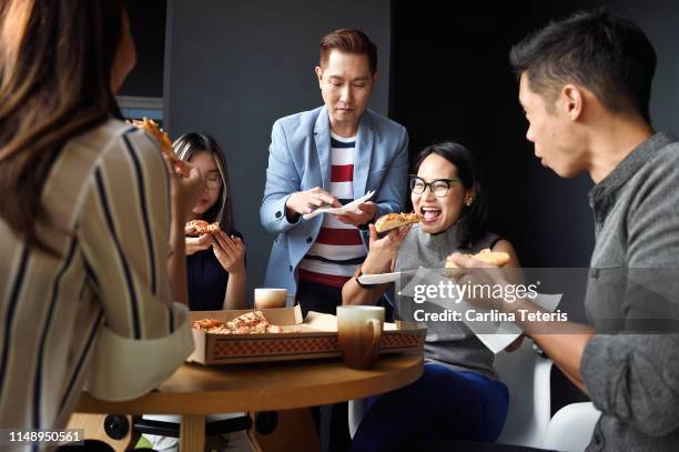 young colleagues eating pizza together - pizza party stock pictures, royalty-free photos & images