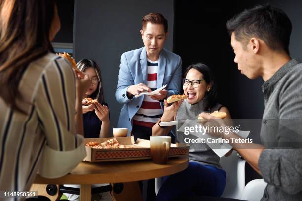 young colleagues eating pizza together - asians eating bildbanksfoton och bilder