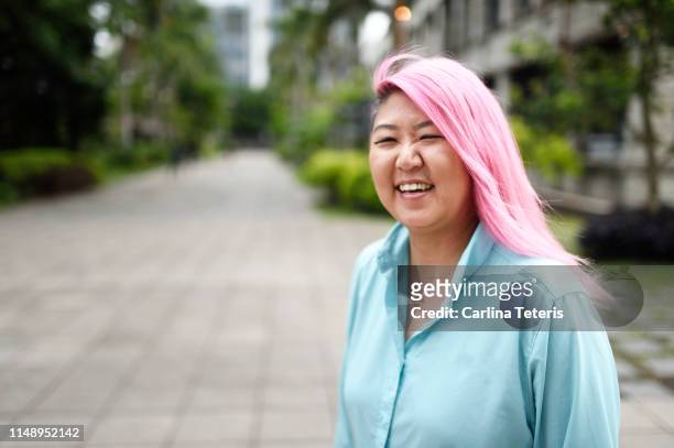 portrait of a woman with long pink hair on a campus - pink hair stock pictures, royalty-free photos & images