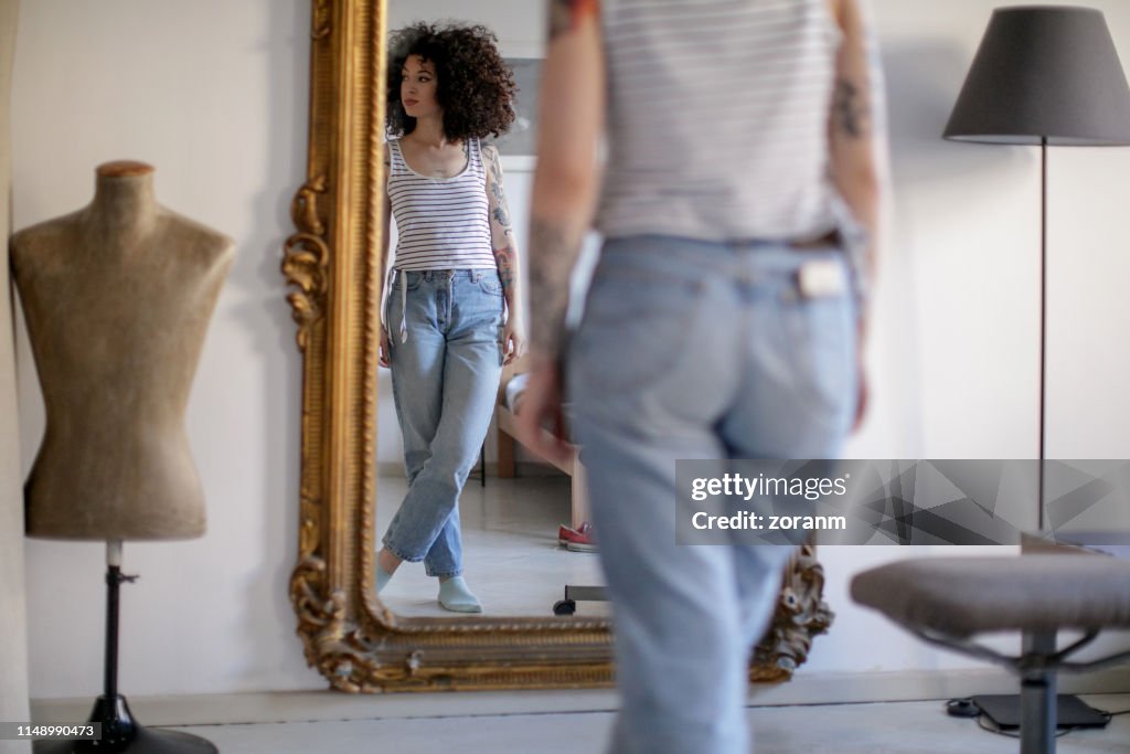 Reflection of young tattooed woman in the mirror